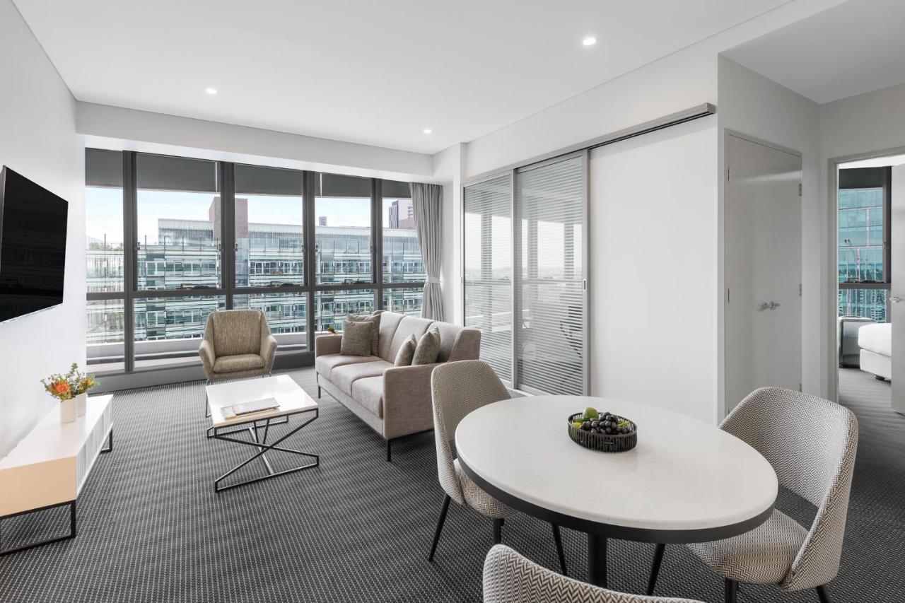 Meriton Suites Herschel Street, Brisbane Dış mekan fotoğraf The photo shows a modern, elegantly designed living space. It features large windows that allow natural light to fill the room, offering a view outside. The interior includes a comfortable seating area with a sofa and armchairs, a coffee table, and a
